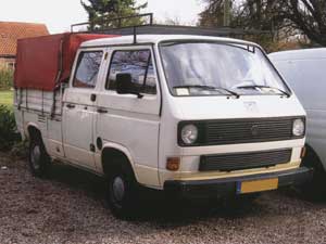 Witte VW T3 dubbelcabine pick-up met rode huif op de laadbak