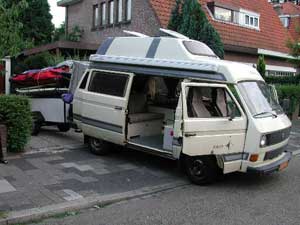 VW T3 camper met geopende portieren en een aanhangwagen er achter