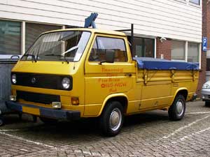 Gele VW T3 enkelcabine pick-up met donkerblauw vlakzeil over de laadbak