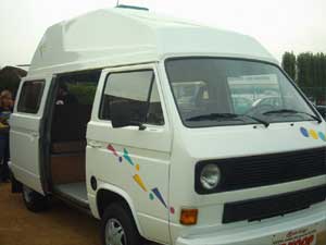 Witte VW T3 camper met kleurige striping op het portier