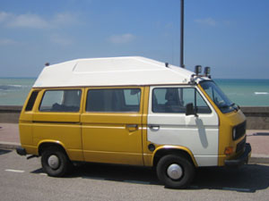 Gele VW camper met wit portier en dak