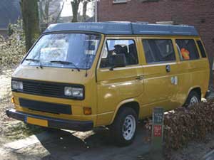 Gele camper met blauw hefdak en witte velgen