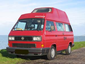 Rode Westfalia camper langs het water