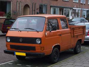 Oranje dubbelcabine pick-up langs de straat