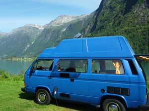 Blauwe T3 camper met reimo dak in bergen landschap